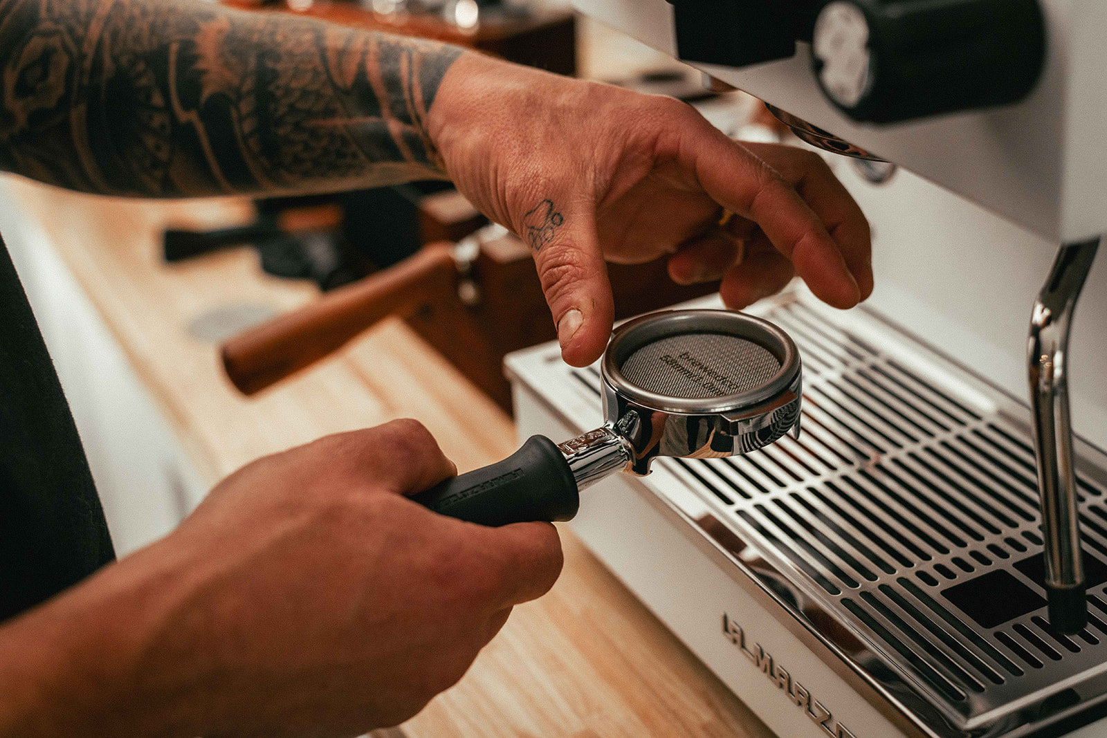 Coffee Puck Screen in Bottomless Portafilter being Tamped by Coffee Tamper