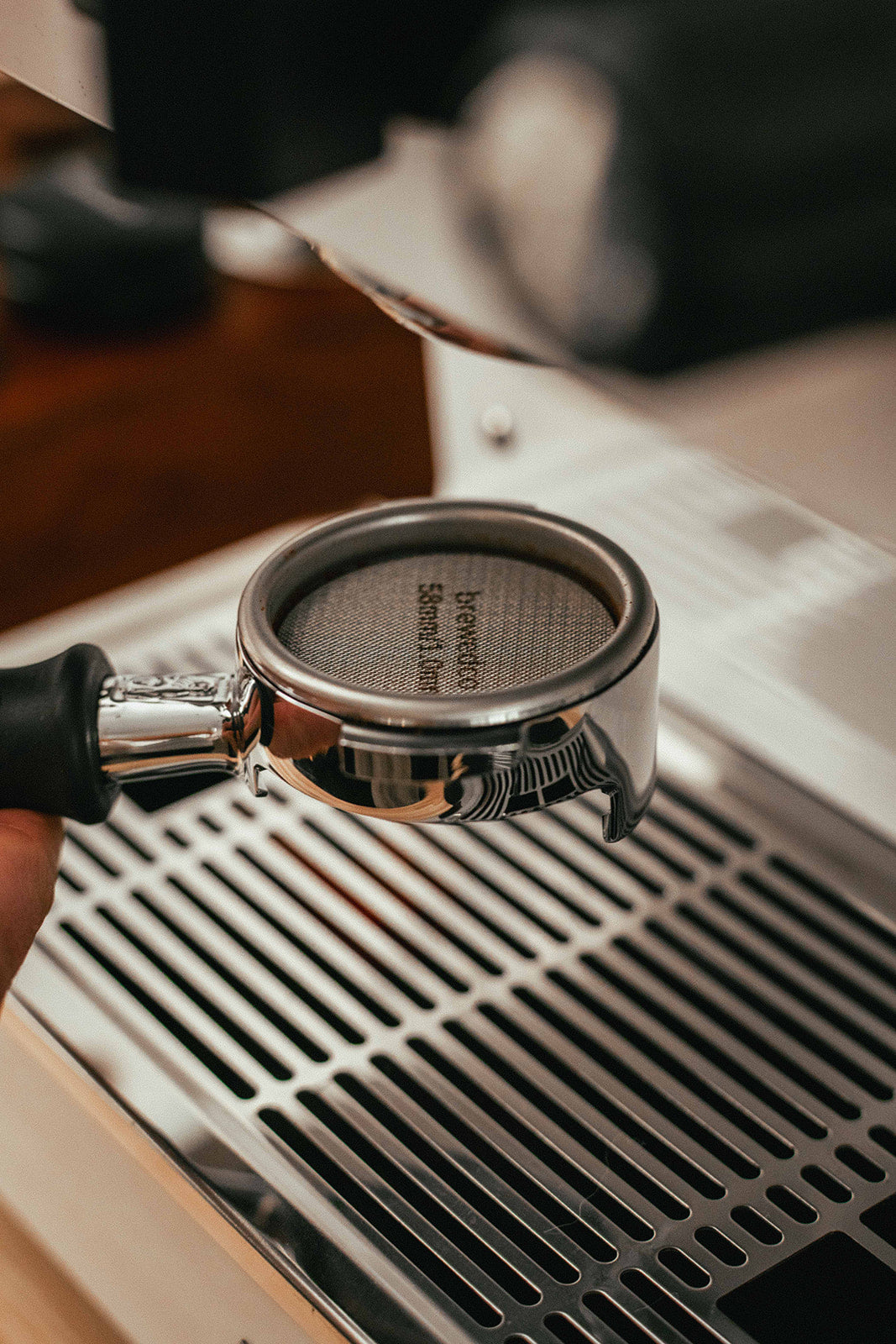 Coffee Puck Screen in Bottomless Portafilter being Tamped by Coffee Tamper